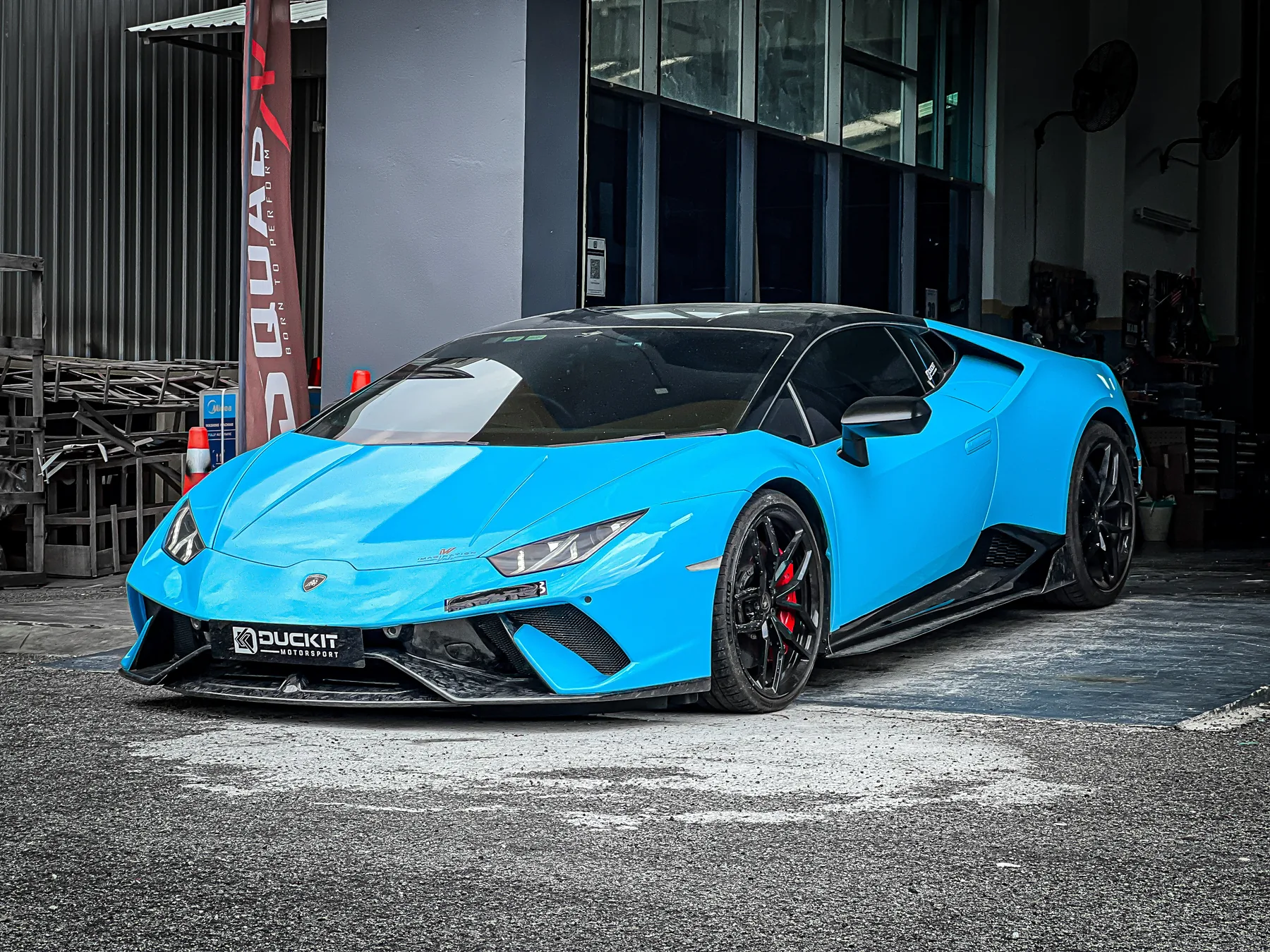Blue Lamborghini Huracan with aero kit outside the Duckit workshop